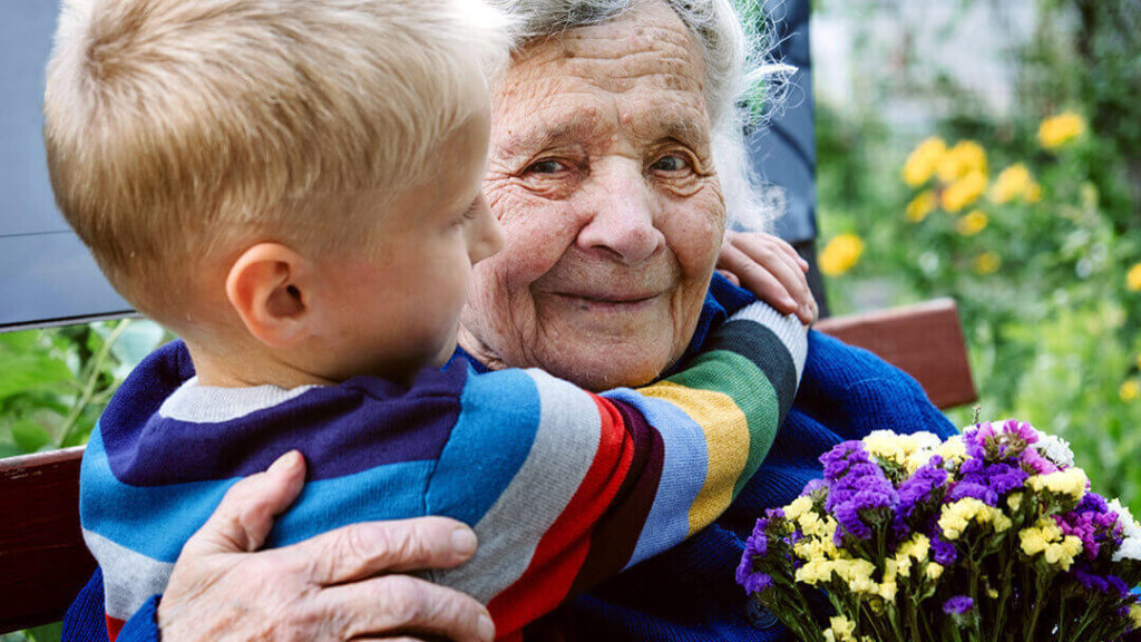 Small boy with arms around grandmother's neck