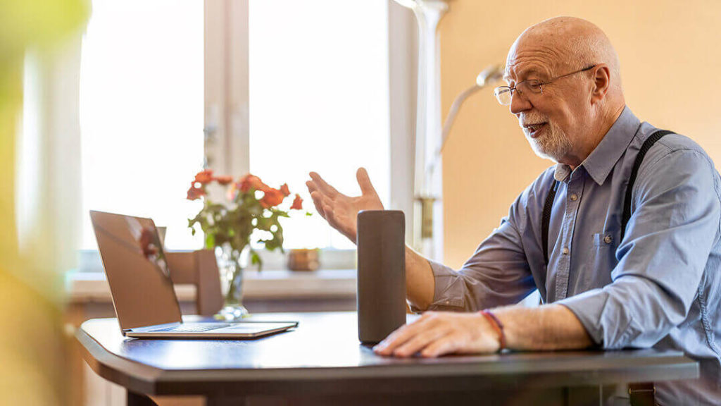 Senior man talking to Alexa device