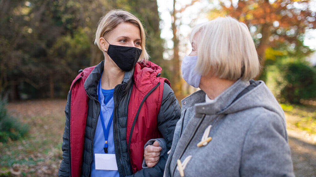 Senior Living Worker Retention - female aid walks with senior woman