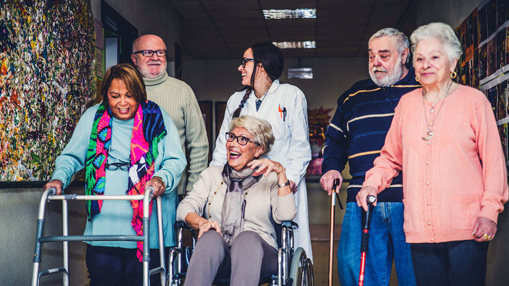 Group of senior citizens walking together in a nursing home