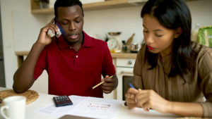 Young couple assessing expenses to pay for their parents elder care